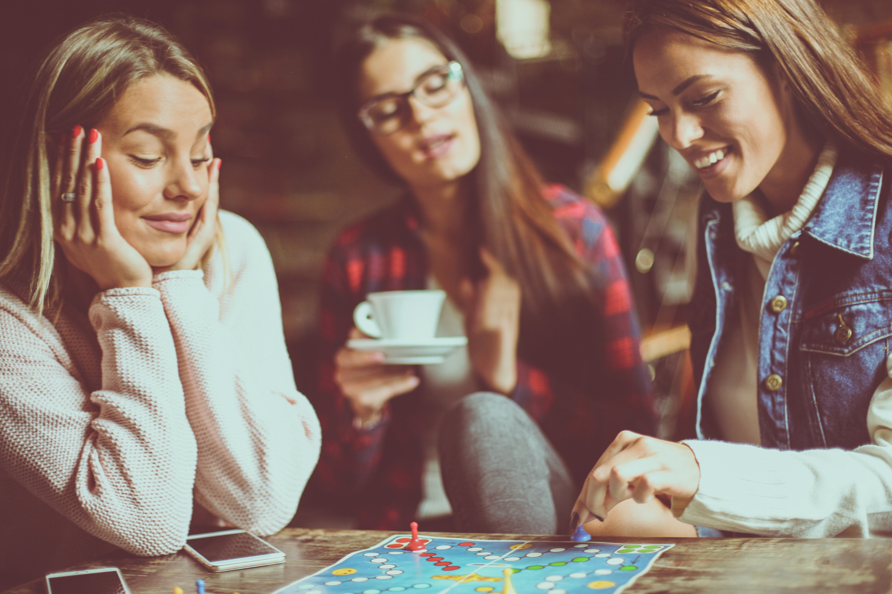 Happy girls playing board game.